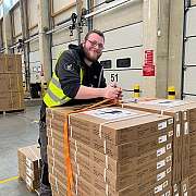 fröhlicher Mann an Pallettenwagen