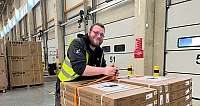 fröhlicher Mann an Pallettenwagen