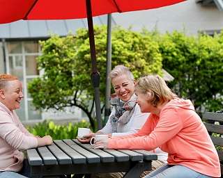 drei lachende Frauen machen Pause